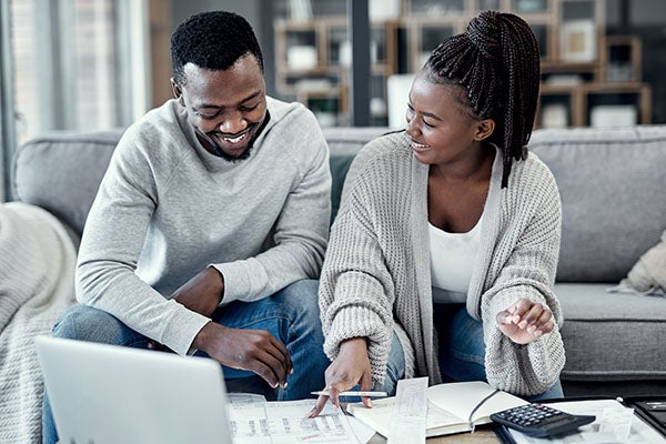 Happy young black couple is happy as they look at their budget