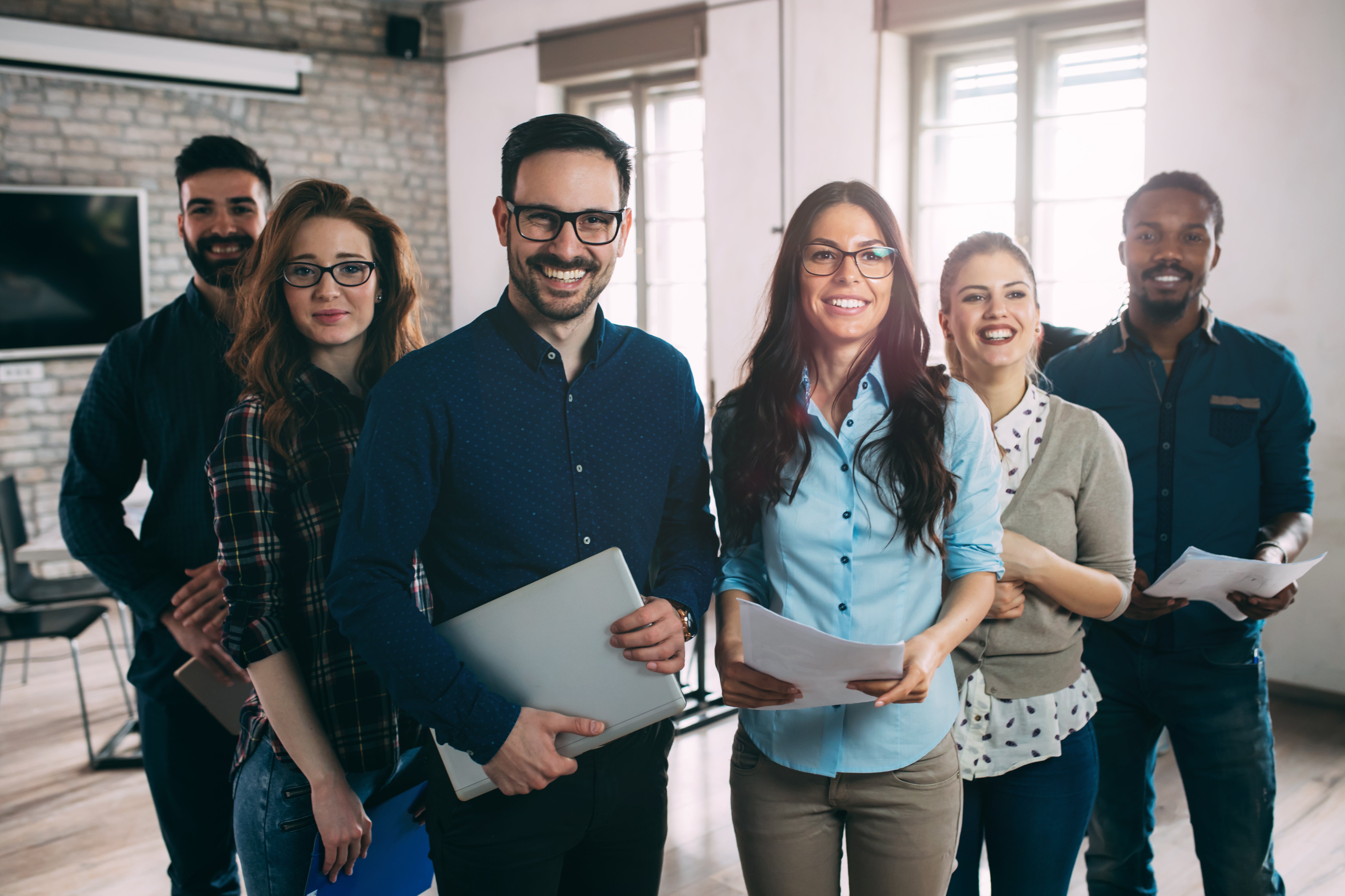 Six smiling coworkers standing together